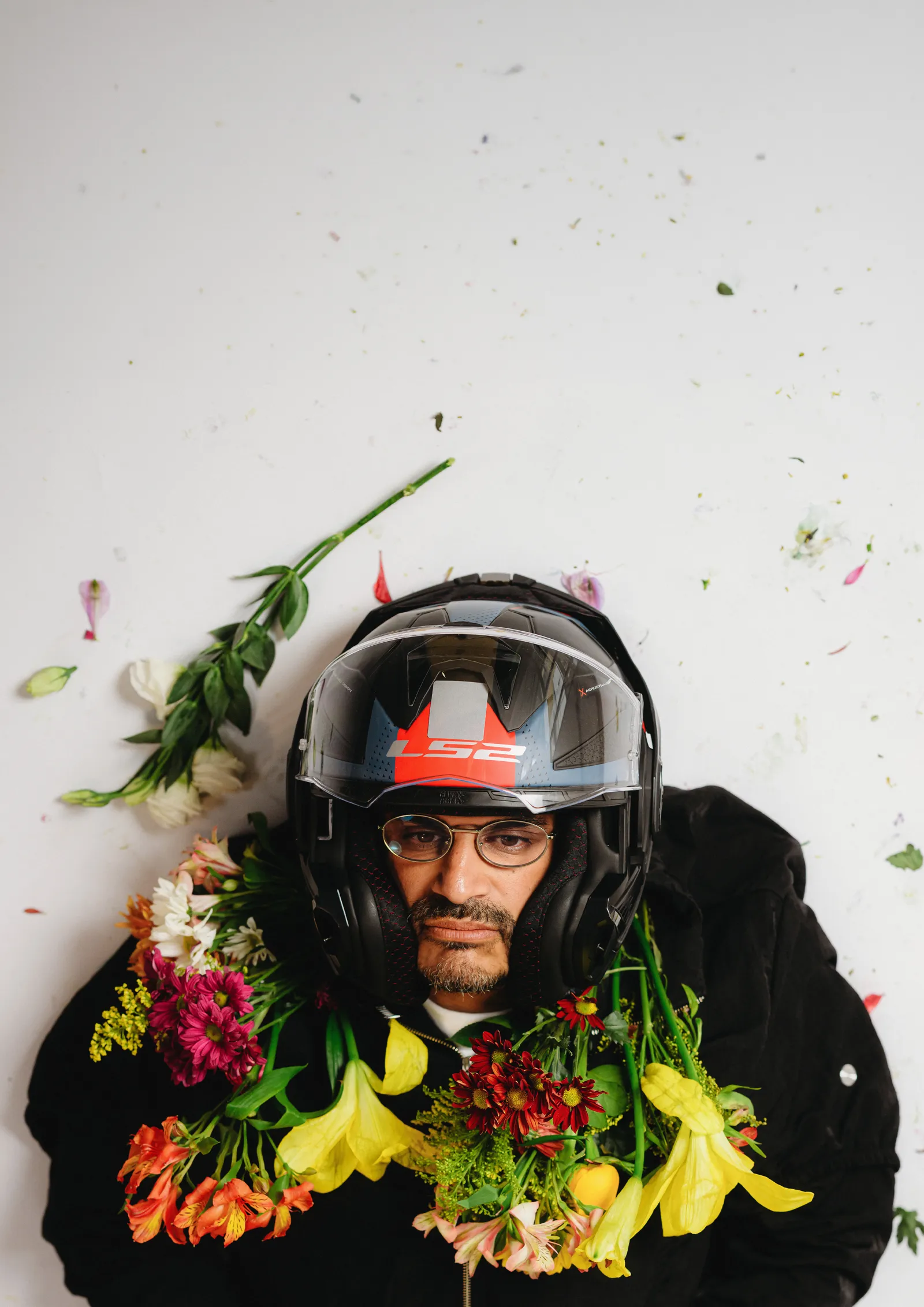 Criolo deitado com capacete e flores sobre fundo branco