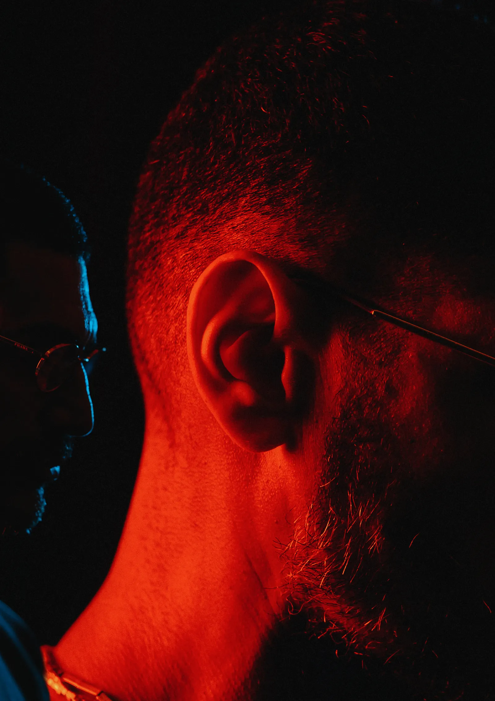 Criolo de perfil sob luz vermelha, detalhe da orelha