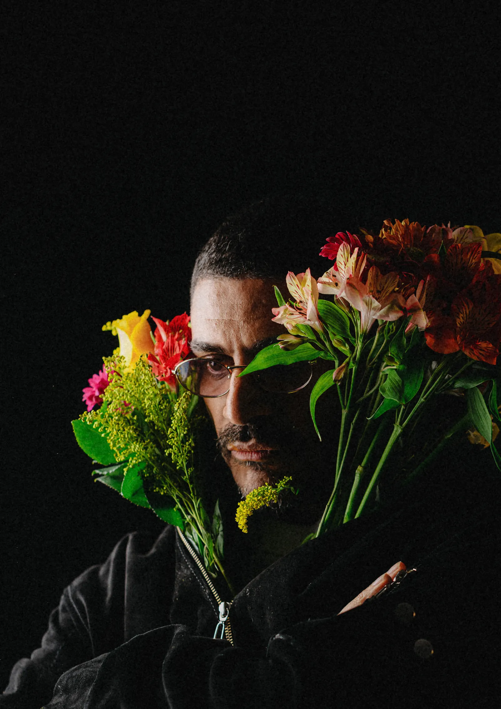 Criolo com um buquê de flores sobre fundo preto